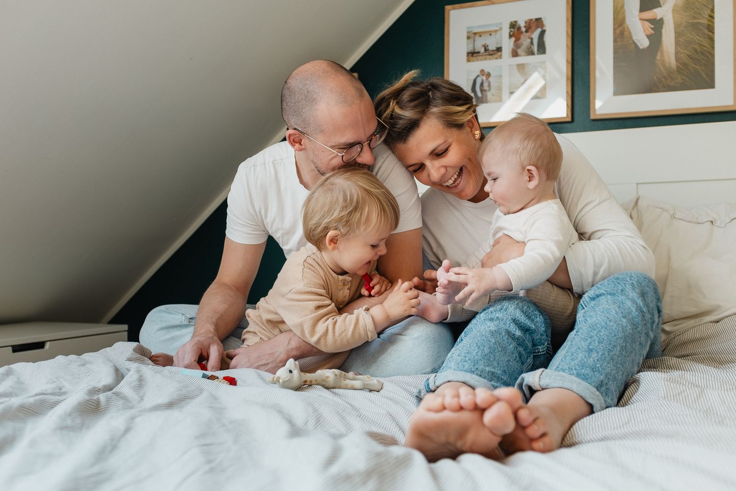 famille jouant sur le lit parental pendant une séance photo de famille à domicile avec Nathalie Klein photographe Lille