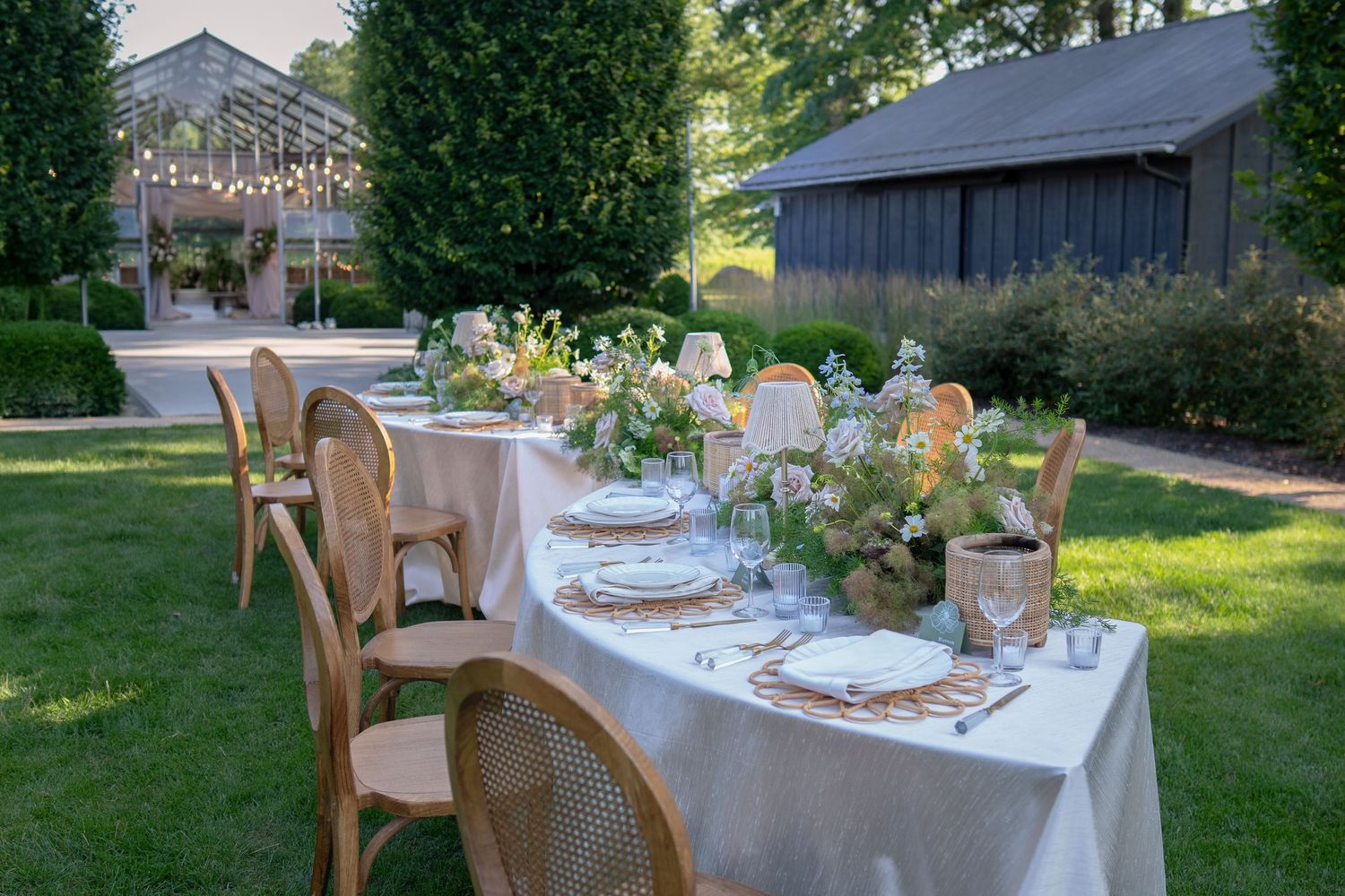 Elegant outdoor wedding table settings with floral centerpieces and wicker chairs at Jorgensen farms