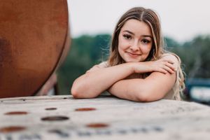 Artistic portrait shot against rustic metal surface in natural lighting.