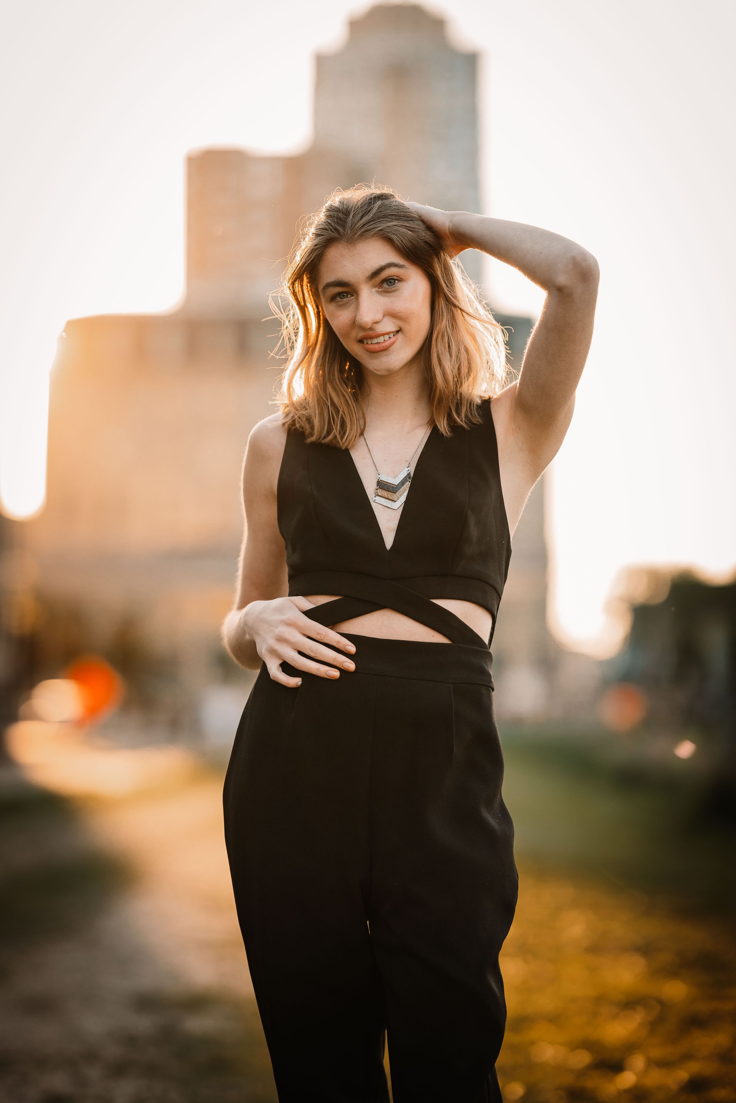 Urban fashion photo with black outfit against sunset cityscape.