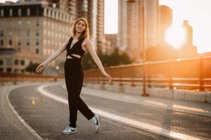 Lifestyle portrait with black streetwear against golden sunset in urban setting.