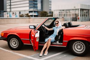 Retro style photograph with classic red Mercedes convertible and blue dress.