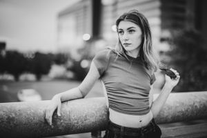 Black and white urban portrait with crop top against city backdrop.