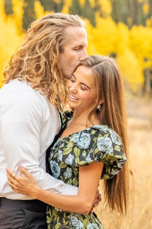 Romantic moment captured in a field surrounded by vibrant yellow fall foliage in Alta Canyon.