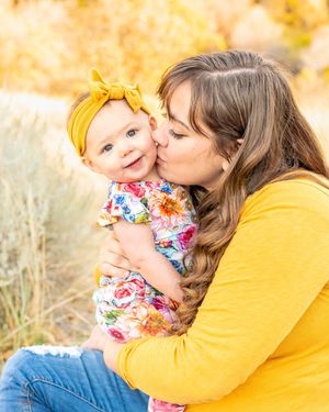 Tender moment shared in golden autumn field with yellow and floral outfits at Hidden Valley Park.