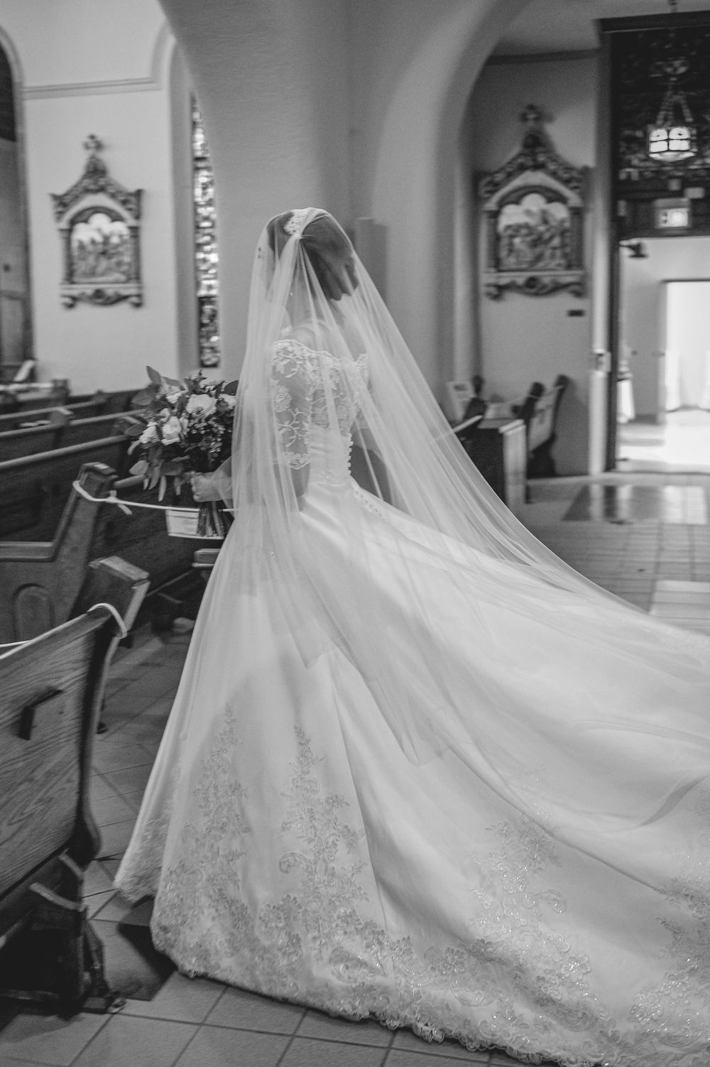 A cathedral wedding scene showcases a flowing white bridal gown with an elegant cathedral-length veil trailing behind.