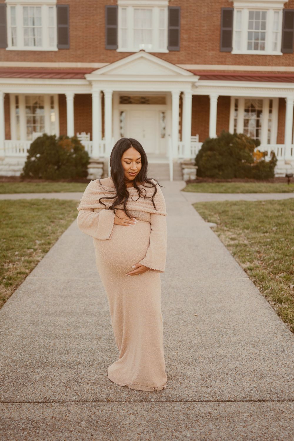 Pregnant woman poses in long elegant modern beige off-the-shoulder dress in Franklin, Tennessee. Photo by Disney Magic Photography