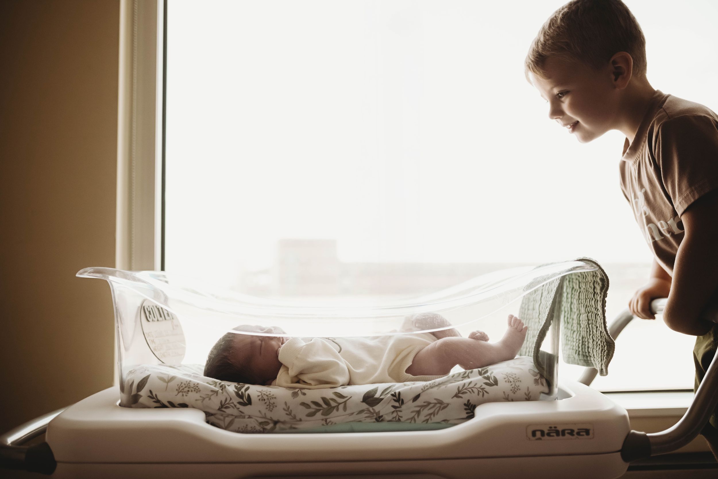 Silhouette style photography of baby on changing table with window backlighting.
