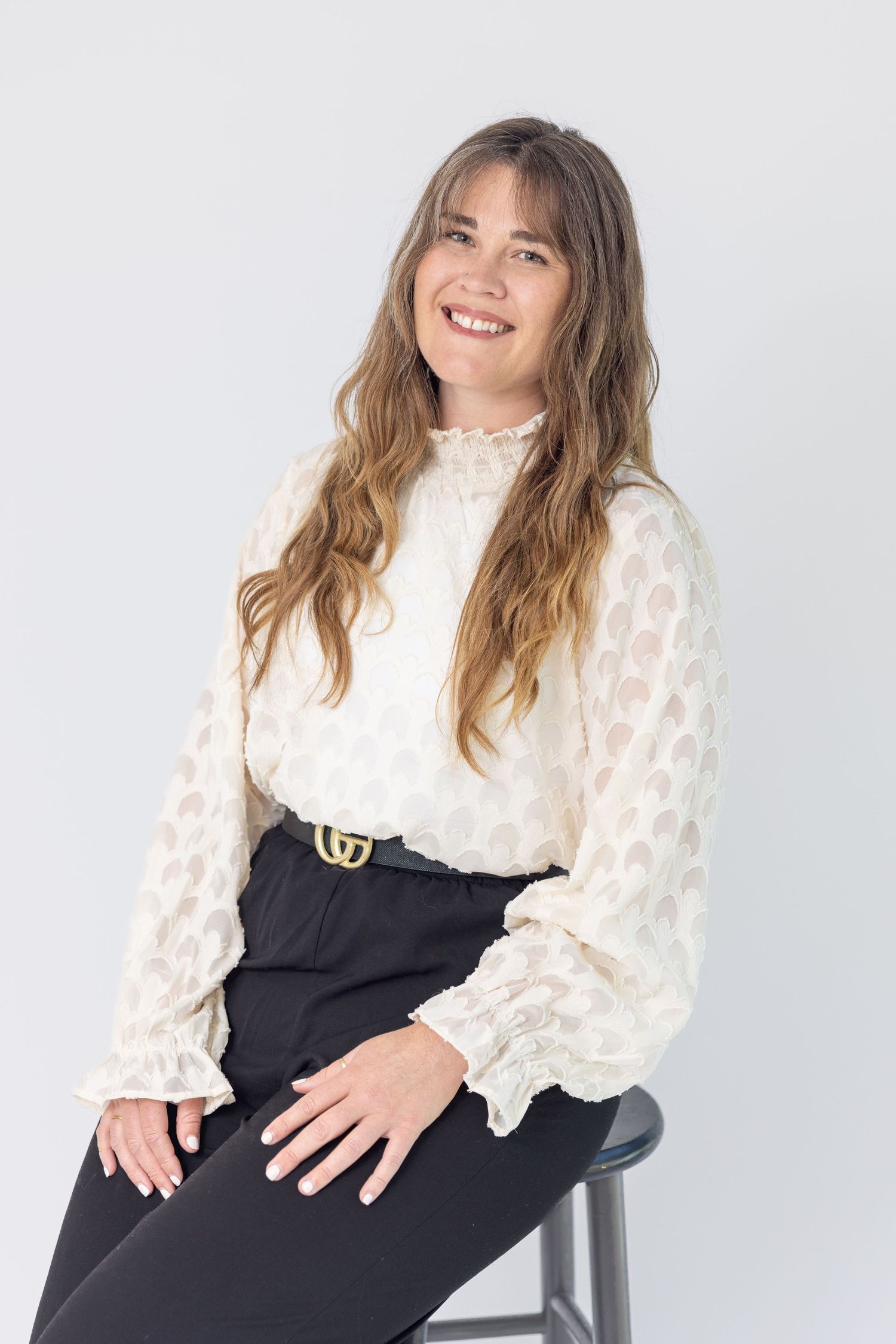 Professional headshot of a person in a business setting, featuring a clean background and natural light.