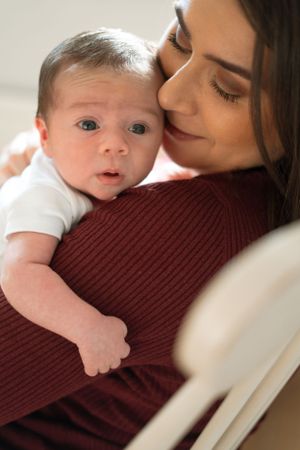 Baby rests against a burgundy sweater in a series of gentle close-up shots.