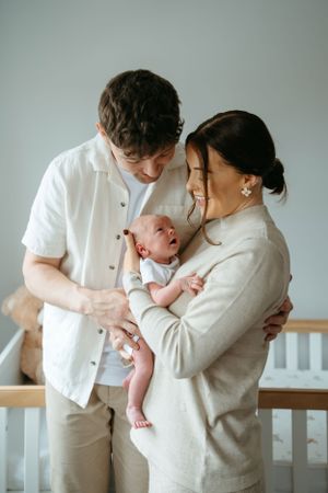 Intimate family portraits in cream and white tones with their newborn.