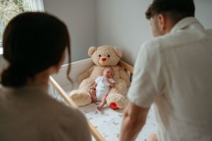 Nursery room scene with teddy bear and baby essentials visible.