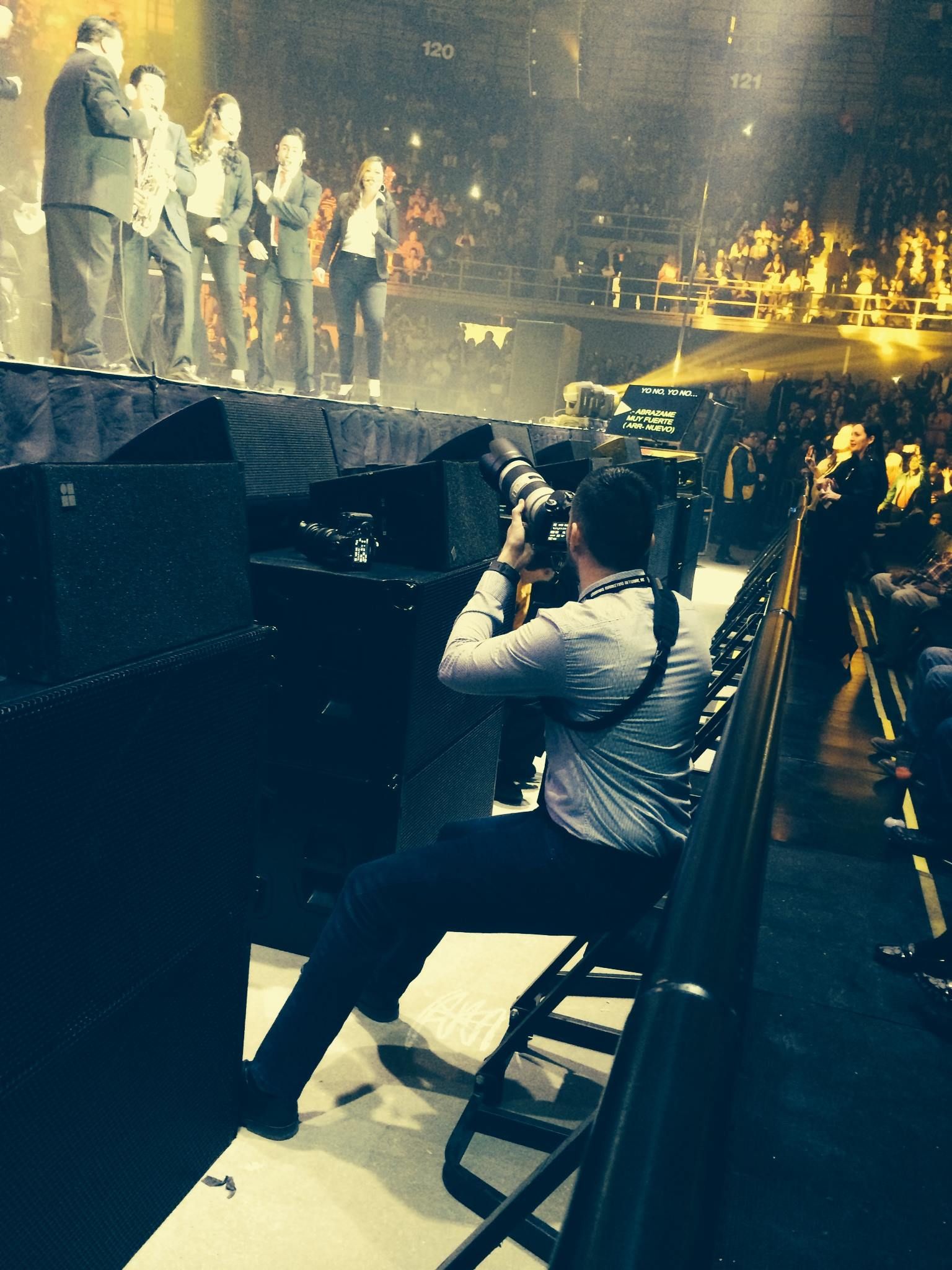 Concert performer on piano creates dramatic silhouette against bright stage lighting during live performance.