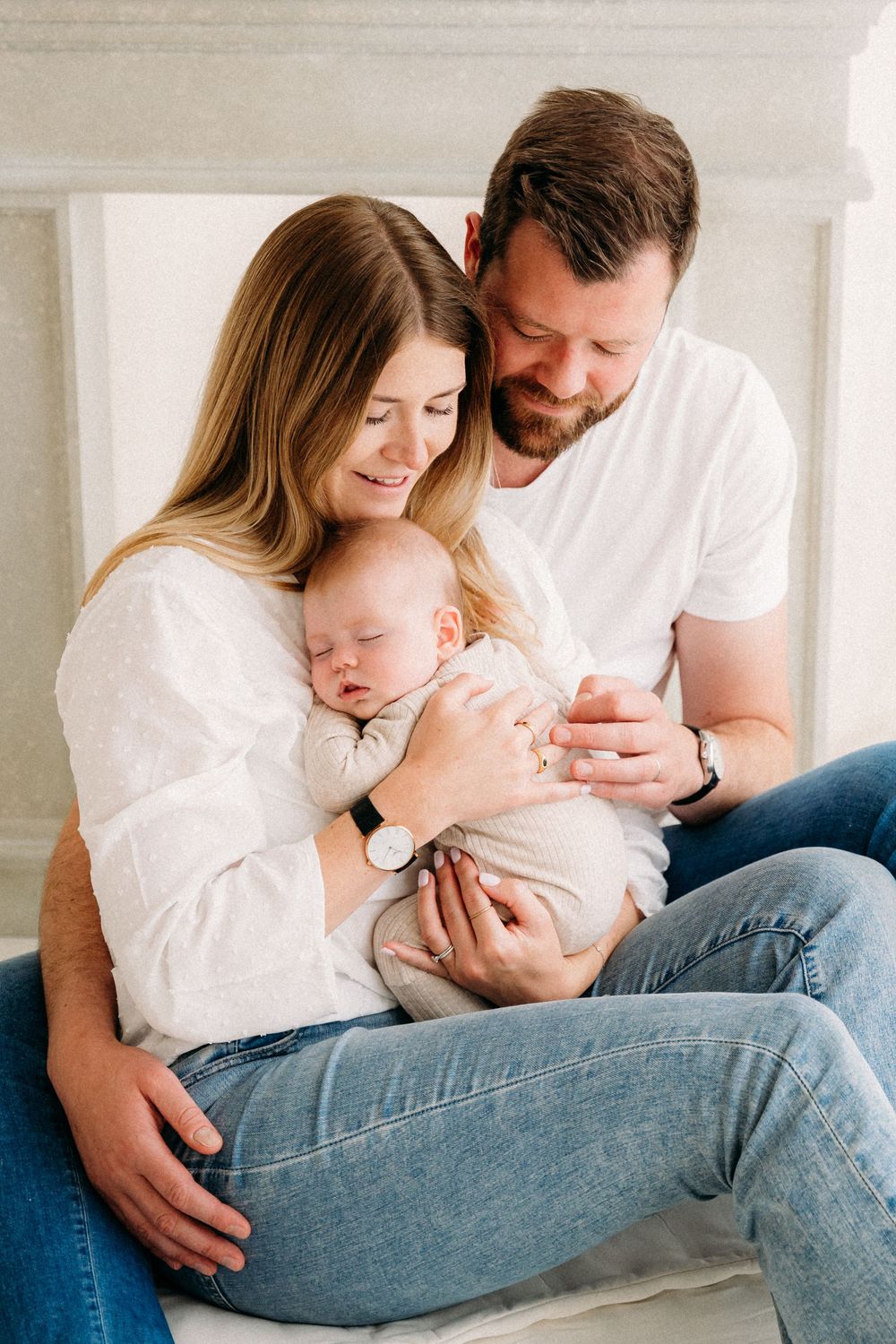 Gezinsfoto met ouders en baby tijdens een babyshoot in daglichtstudio