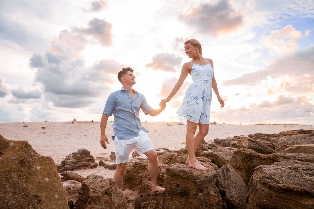 A proposal scene on rocky coastal terrain during sunset.