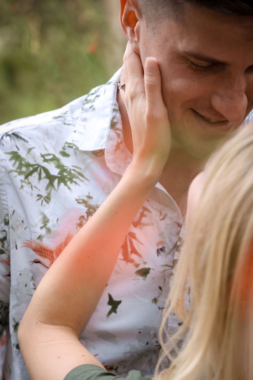 A tender moment captured between a couple with a floral backdrop.