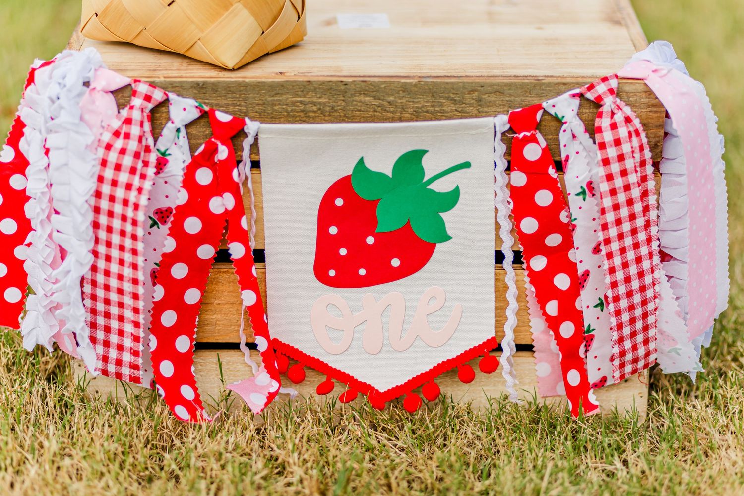 Decorative strawberry-themed banner with red and white gingham fabric strips.