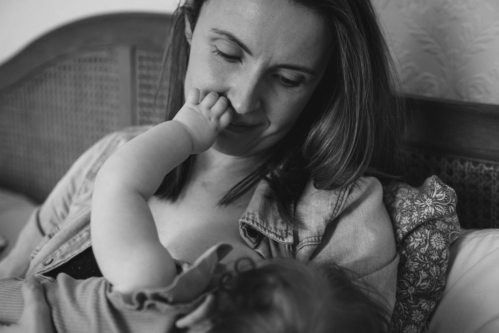 Intimate moment of parent and baby resting together in chair.
