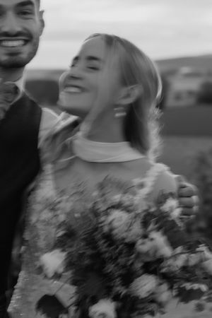 Black and white candid moment of joy during a wedding photoshoot.
