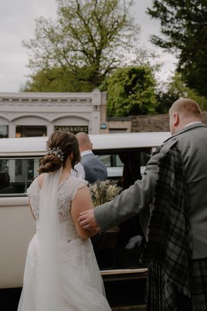 Bride and guest approach vintage white van outside Cameratiks building.