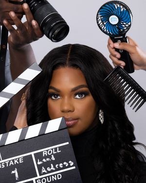 Behind the scenes photo shoot setup with camera, clapboard, fan and beauty lighting.