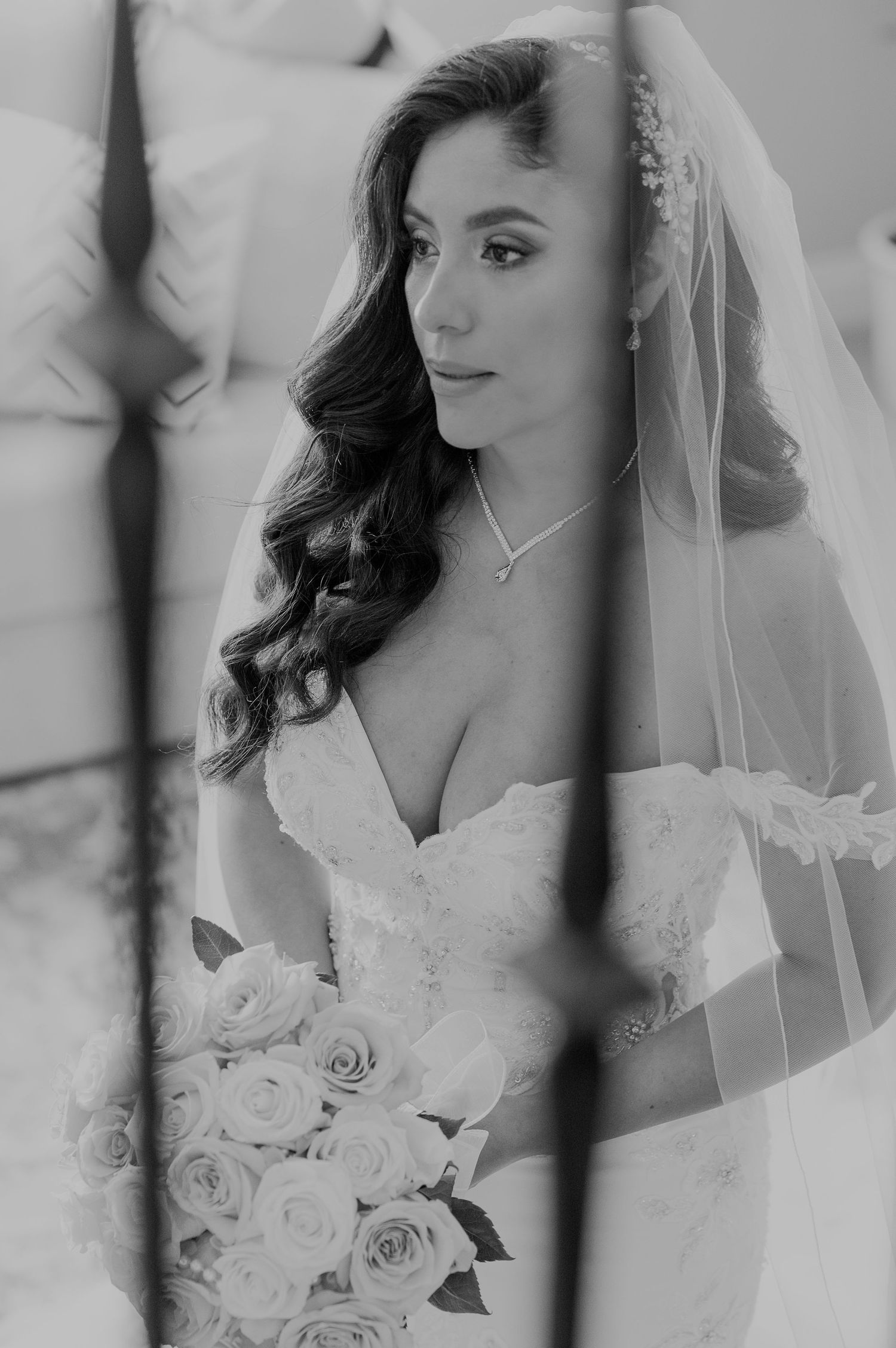 Romantic black and white bridal portrait with roses and veil.