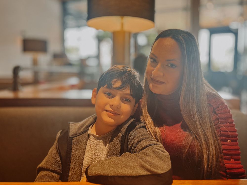 Two people sharing a cozy moment at a restaurant booth with warm lighting.