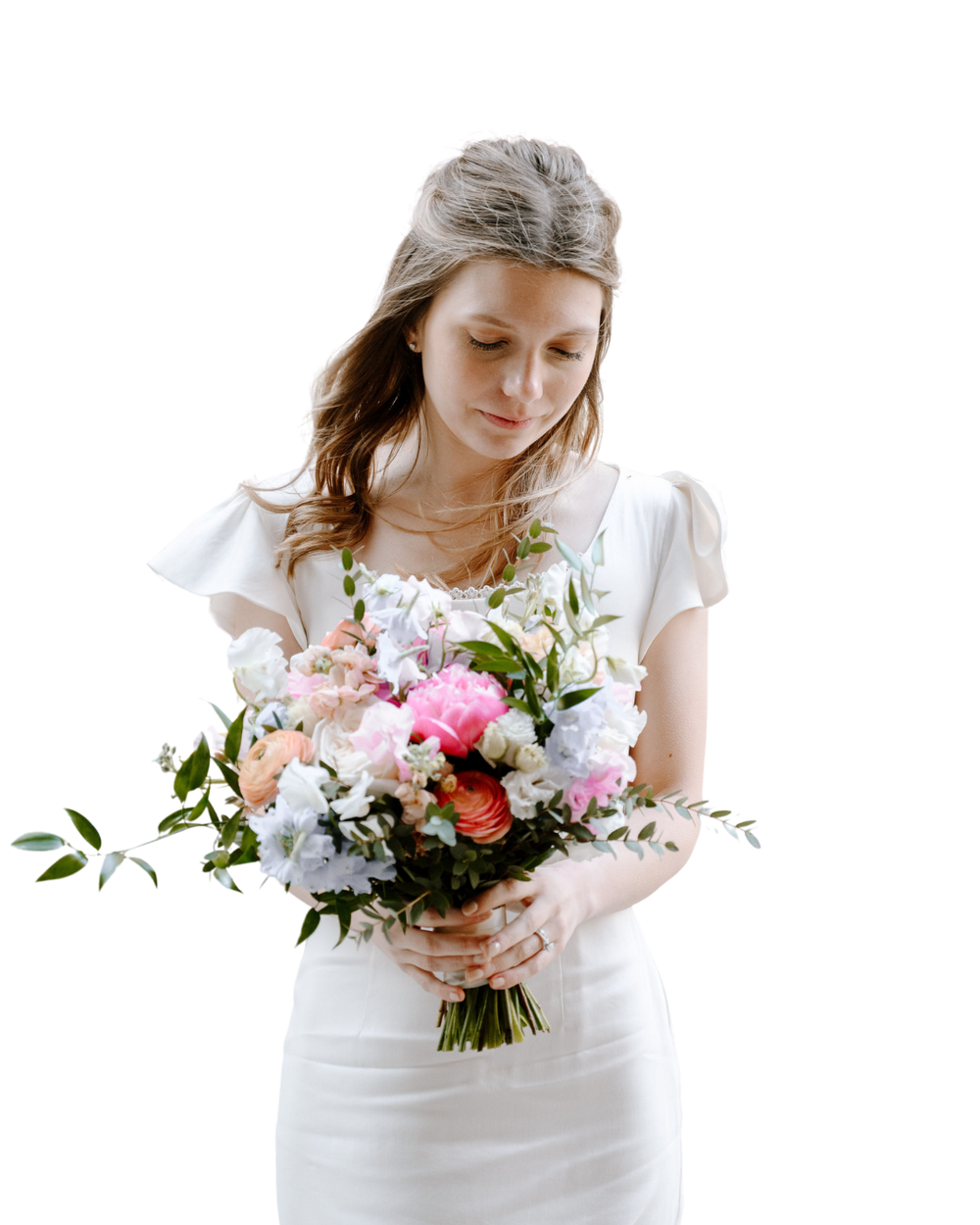A graceful person in a white dress holds a lovely mixed bouquet of pink, peach and purple flowers with greenery.