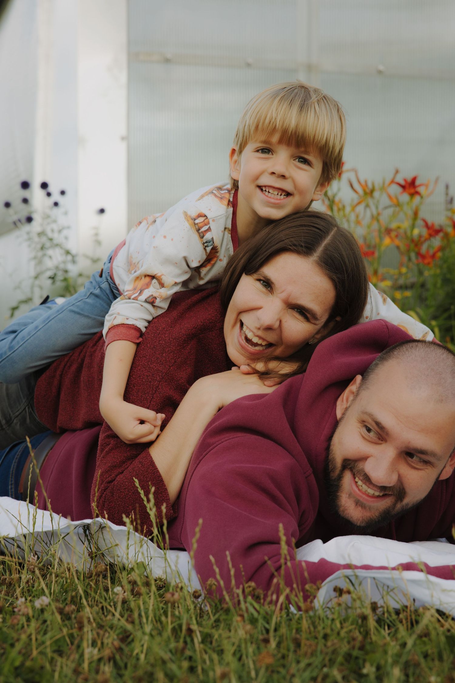 Playing and laughing with a wheelbarrow in an overgrown garden.