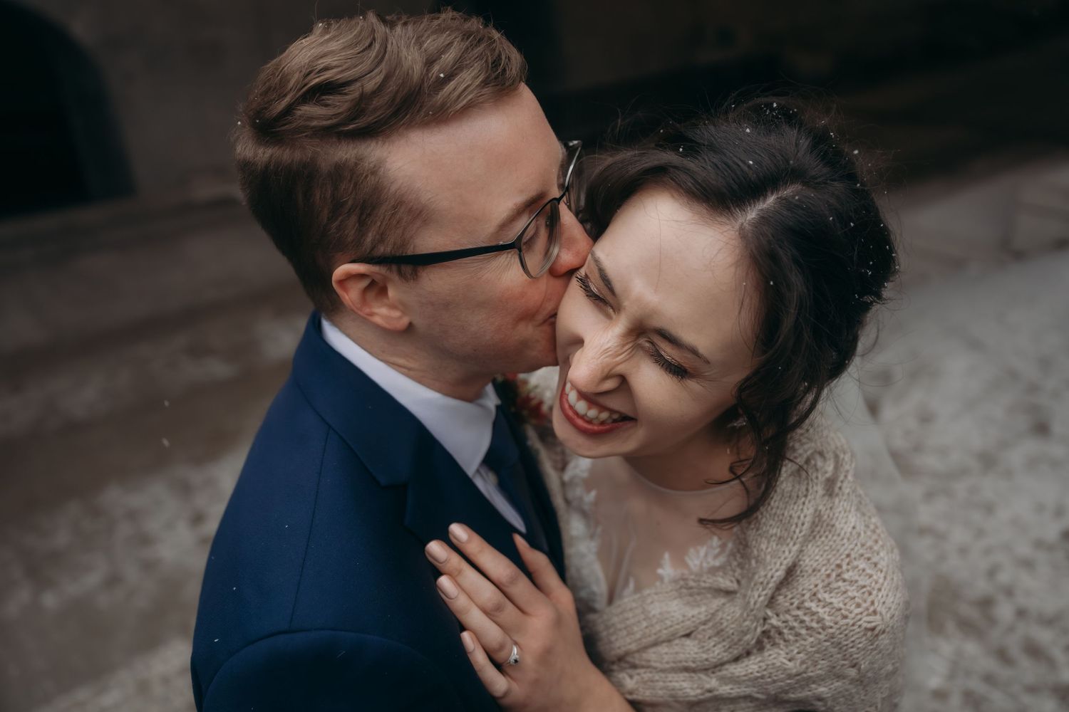 Close up of tender moment between newlyweds in elegant wedding attire.