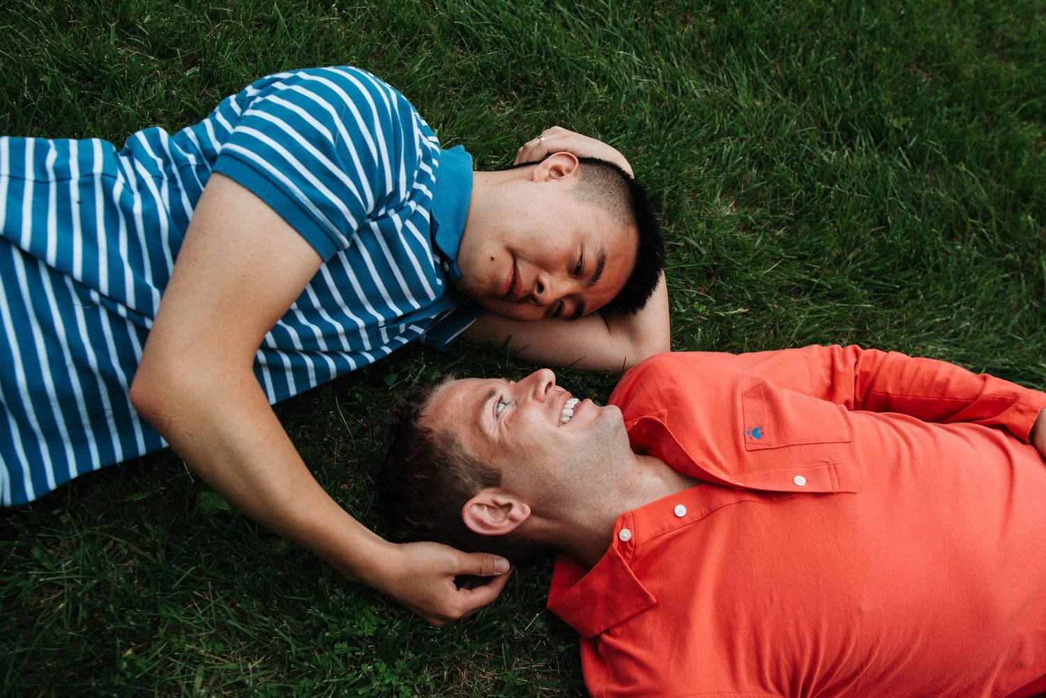 Series of people lying on grass in striped shirts and coral clothing.