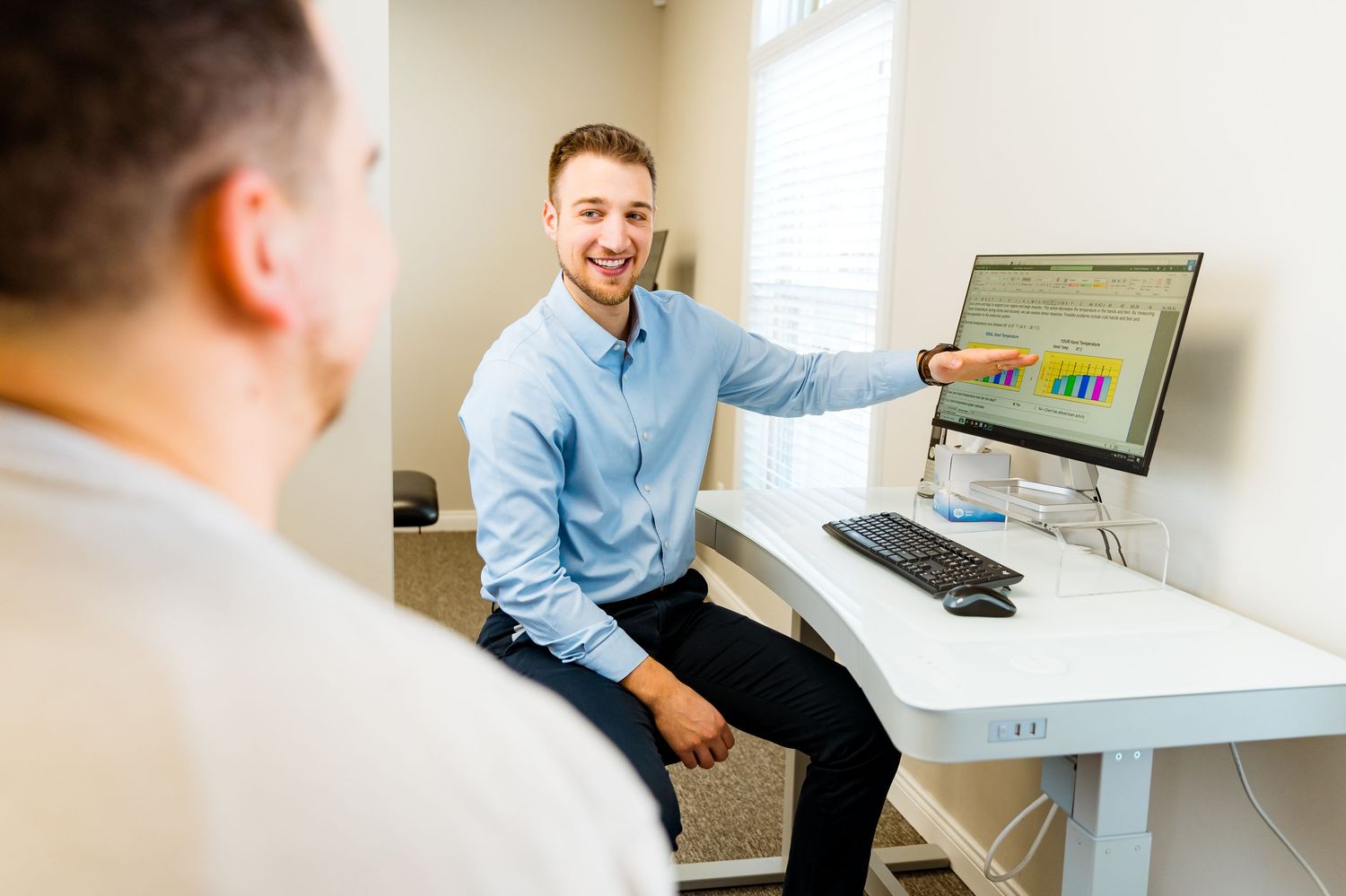 Michigan Commercial Videographer captures Business professional pointing to financial graphs displayed on computer monitor