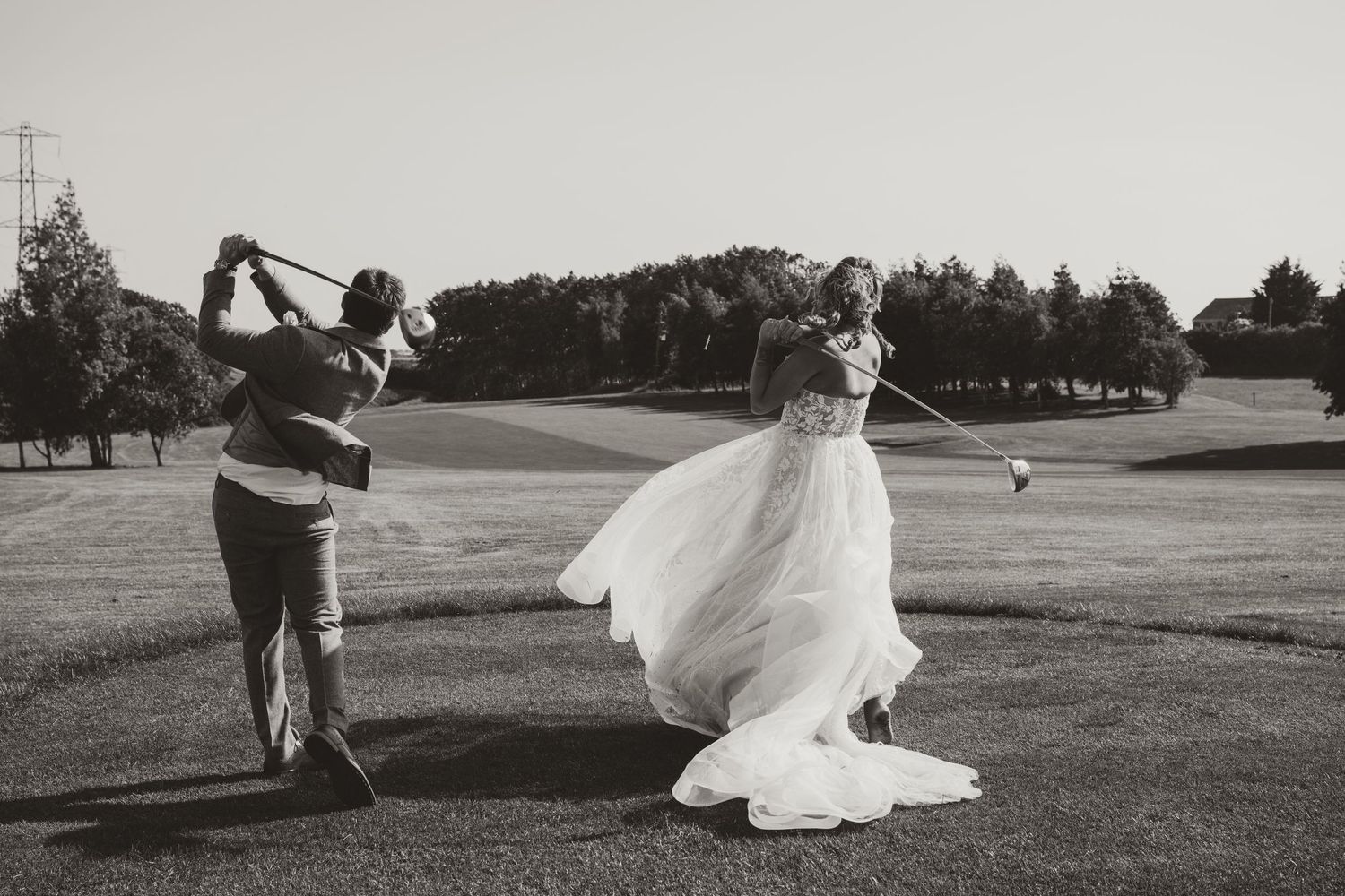 Black and white panoramic series captures playful wedding couple moments in an open field.