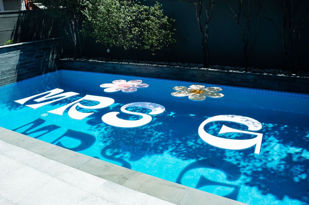 Bright blue swimming pool with USA letters and stars painted in white and red on the surface.
