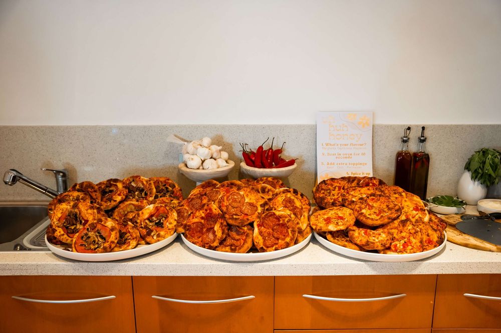 Rows of spicy Buffalo chicken wings arranged on buffet platters with various dipping sauces and accompaniments.