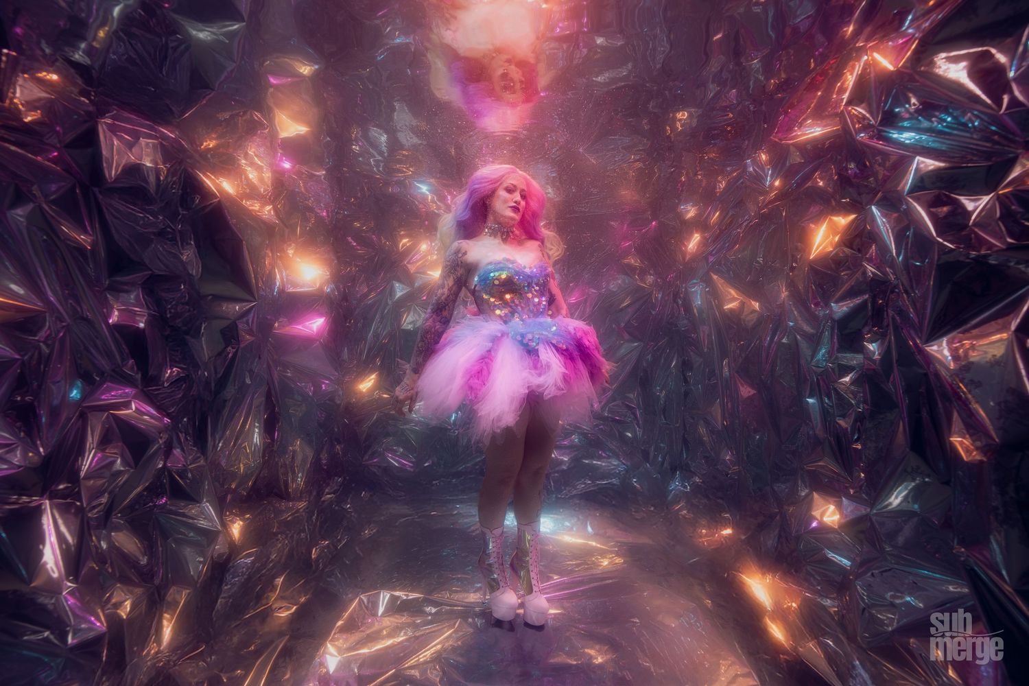 A dancer in a flowing pink dress performs underwater surrounded by kelp in a magical aquatic scene with ethereal lighting.