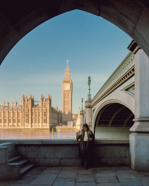 View of Houses of Parliament and Big Ben through Westminster Bridge arch in London.
