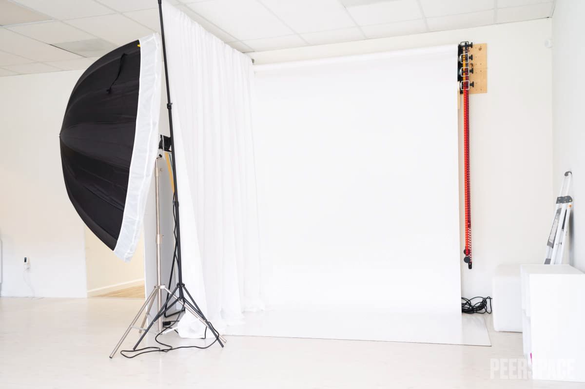 Professional photography studio setup with large black softbox and white backdrop.