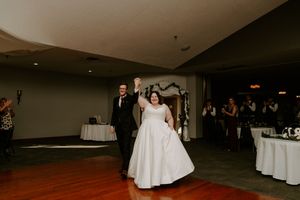 Wedding reception venue with white tablecloths and ambient lighting.
