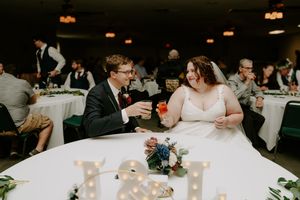 Wedding reception tables set with white linens and floral centerpieces.