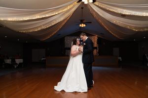 Wedding reception venue decorated with elegant draped fabric and warm lighting for first dance.