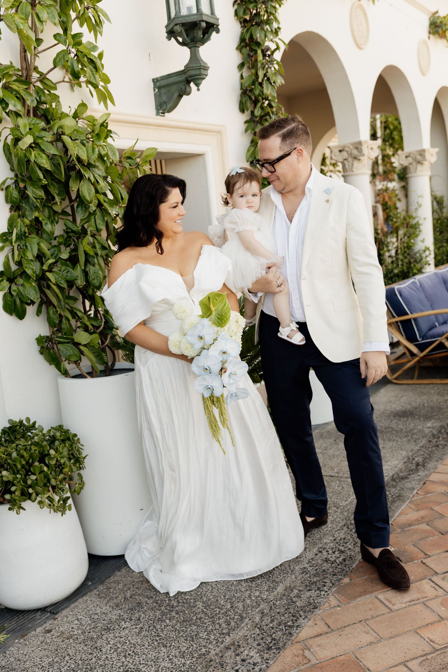 A touching wedding moment captured in a series of photos showing interactions along an elegant arched walkway with potted plants.