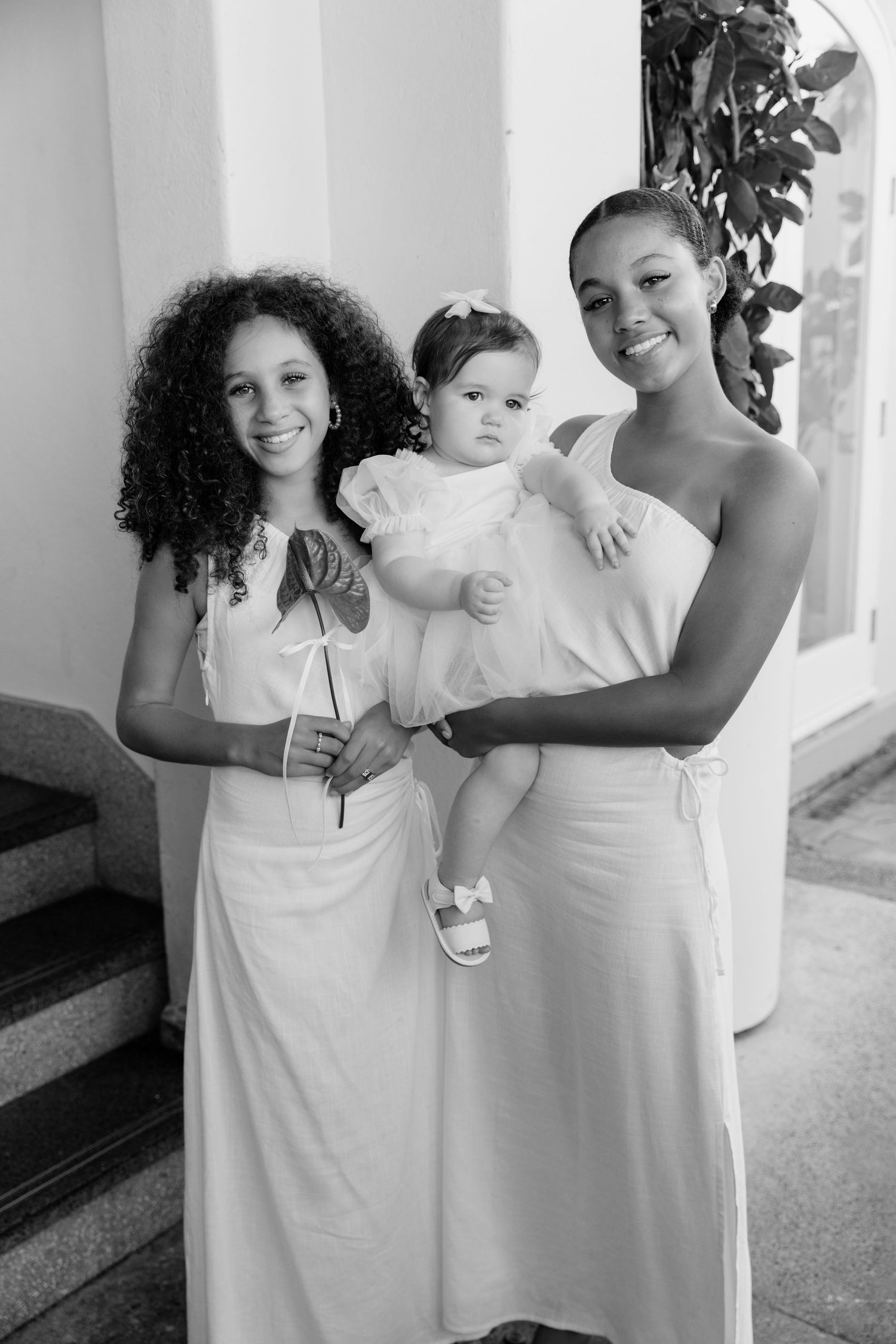 A series of black and white candid photos showing two people in white dresses sharing joyful moments together.