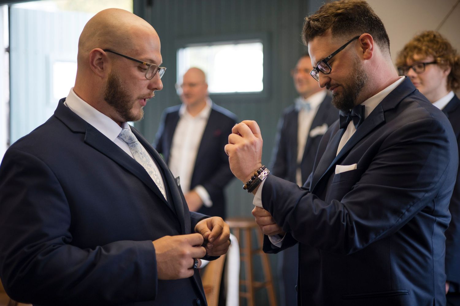 Business professionals in suits gather around a table during a corporate meeting or discussion.