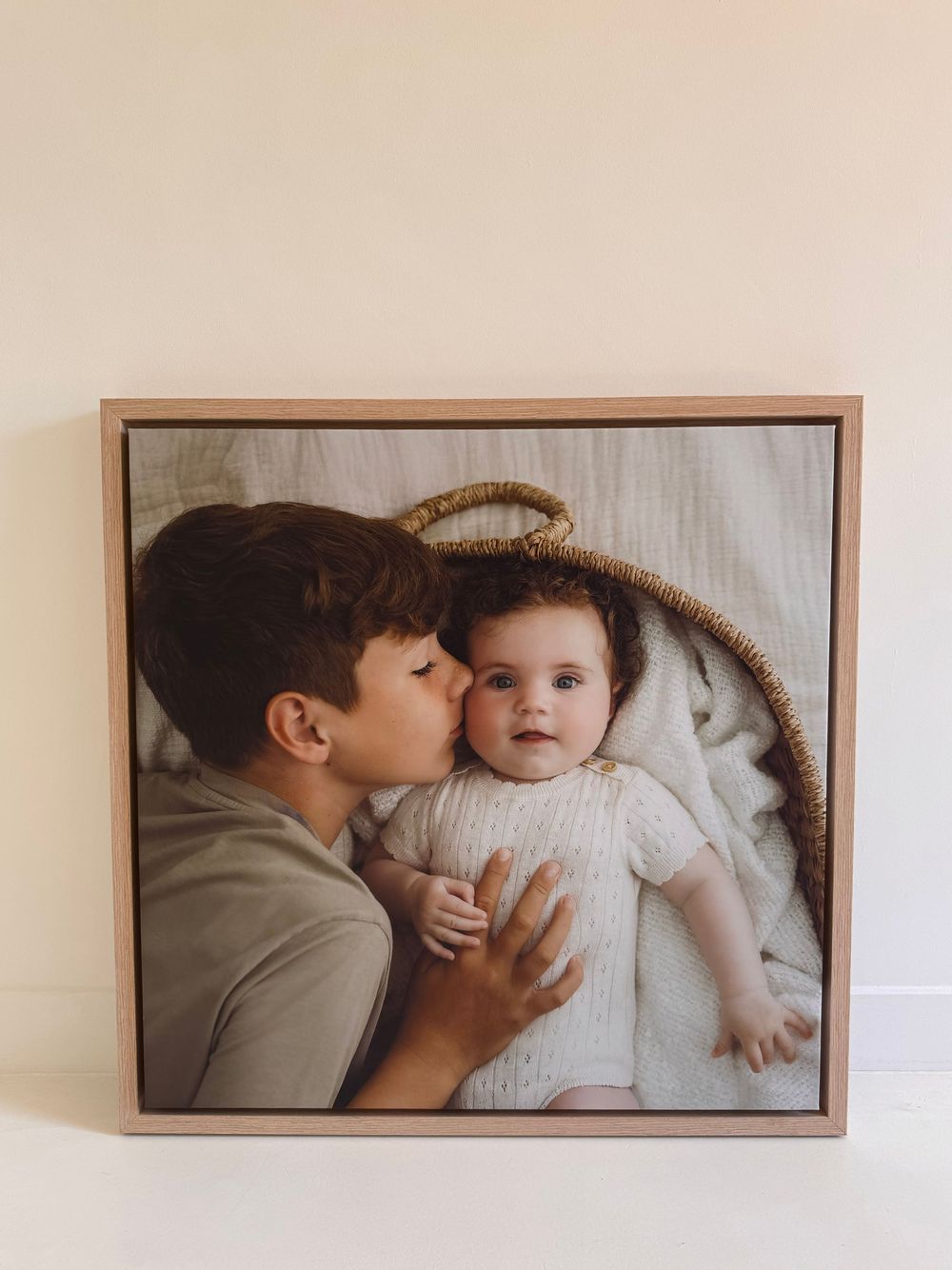 A heartwarming moment captured in a framed photo showing affectionate interaction with a baby wearing a white knit sweater.
