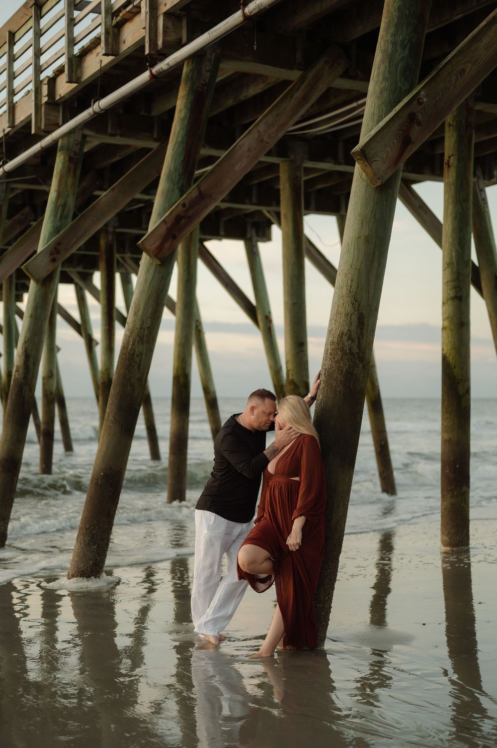 couple kissing under pier in Myrtle Beach,sc