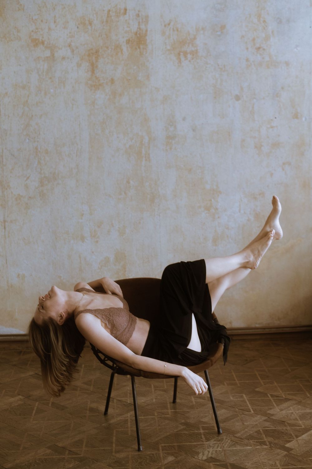 Artistic sequence showing figure suspended above chair in sepia-toned photography.