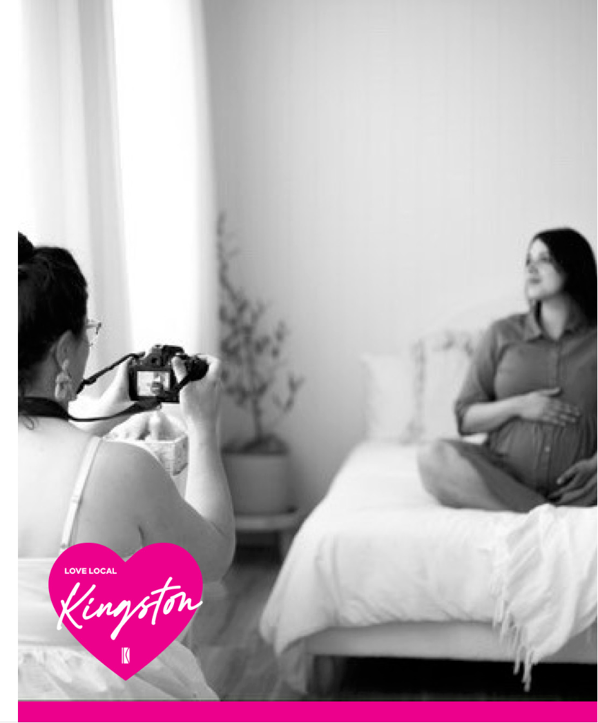 A black and white photo of a maternity photography session in progress.