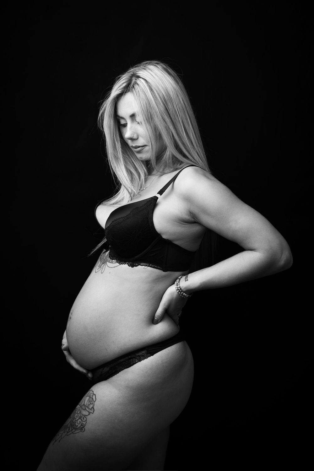 Black and white artistic maternity photos showing silhouettes against dark background.