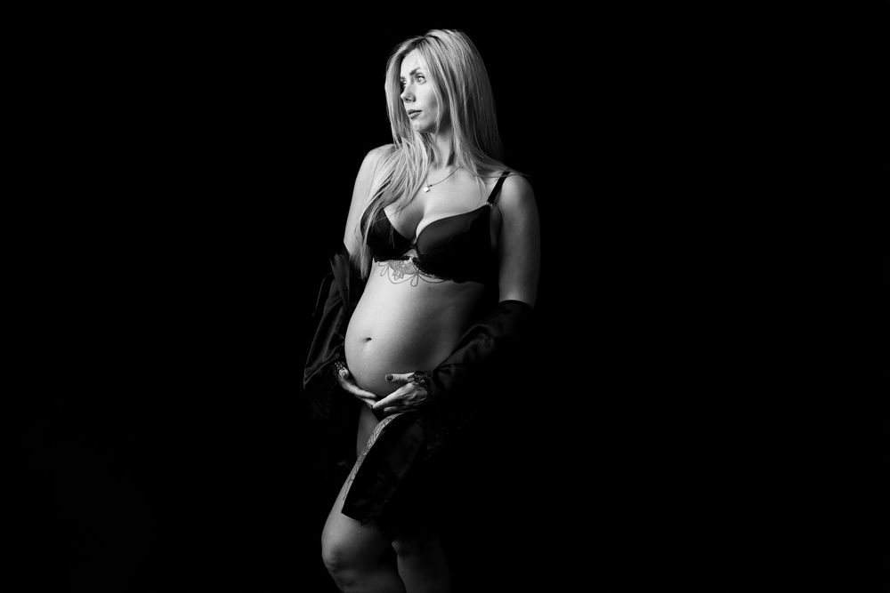 Dramatic black and white maternity portraits with side lighting.